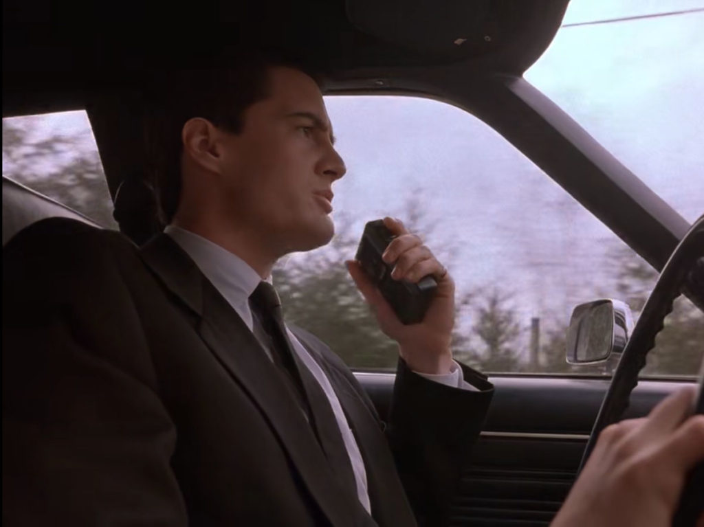 Agent Cooper's driving his Dodge Diplomat car speaking into a handheld tape recorder