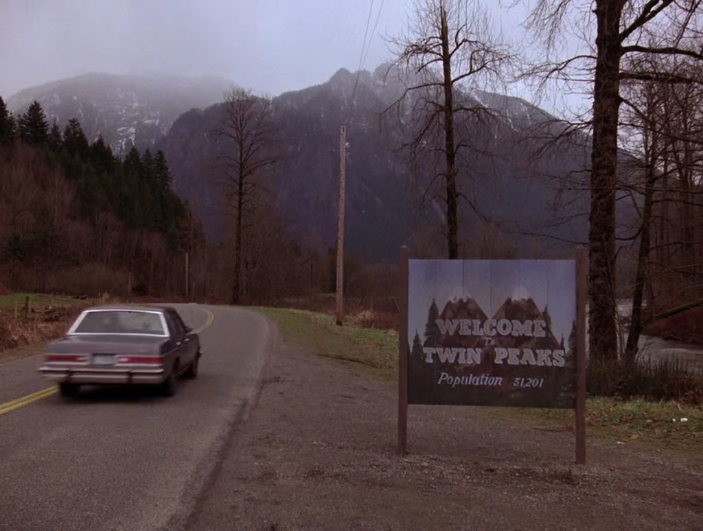 Agent Cooper's car passing the Welcome to Twin Peaks Sign