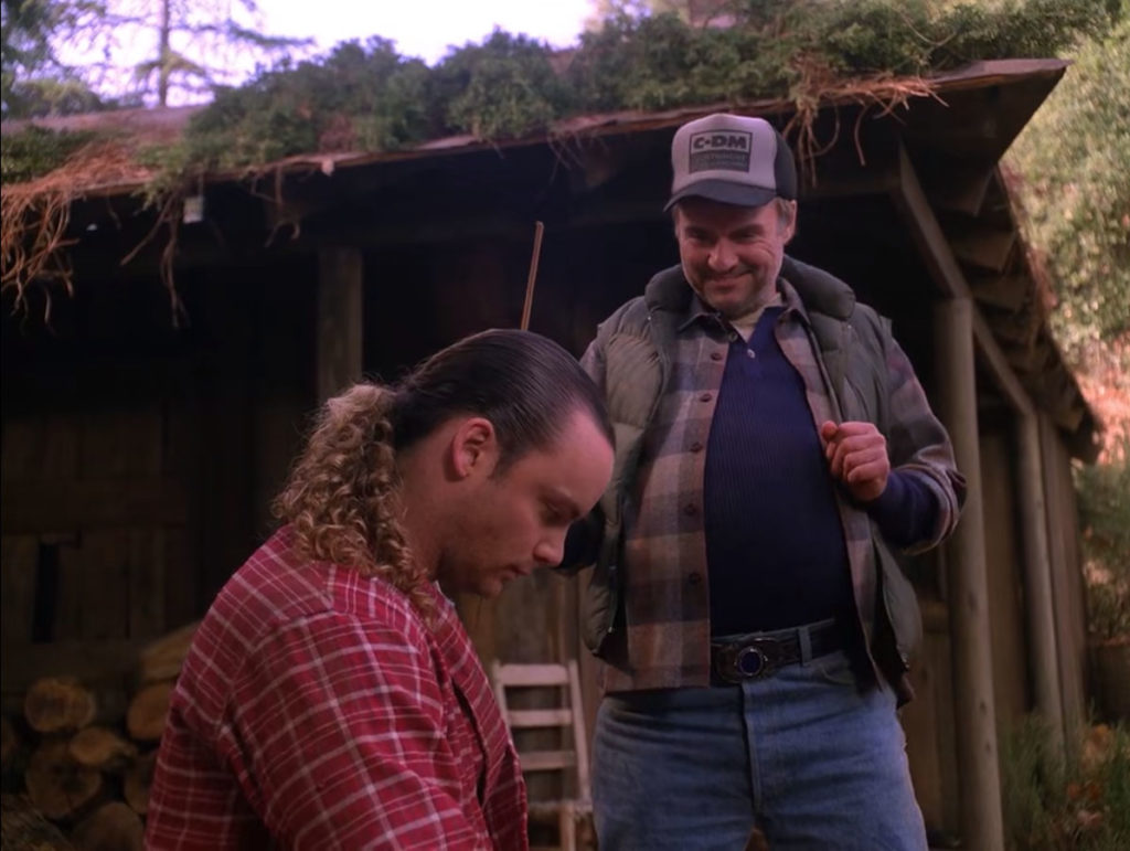 Windom Earle's wearing a hat talking to Leo Johnson outside his cabin