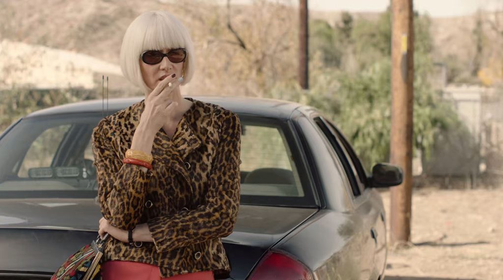 Diane Evans smoking while leaning against the back of a car