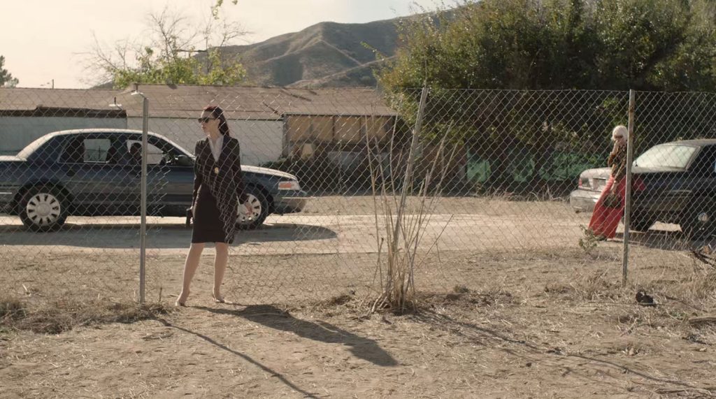 Agent Tammy Preston and Diane Evans wait behind a chain-link fence