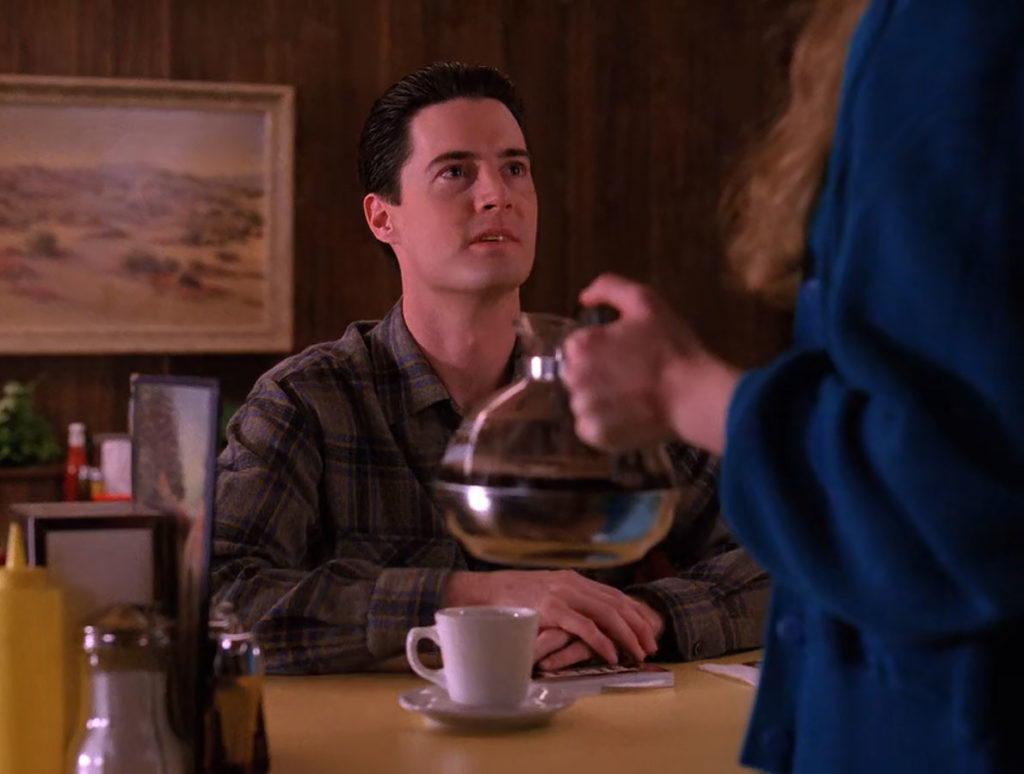 Dale Cooper speaking with Annie Blackburn while she holds a decanter