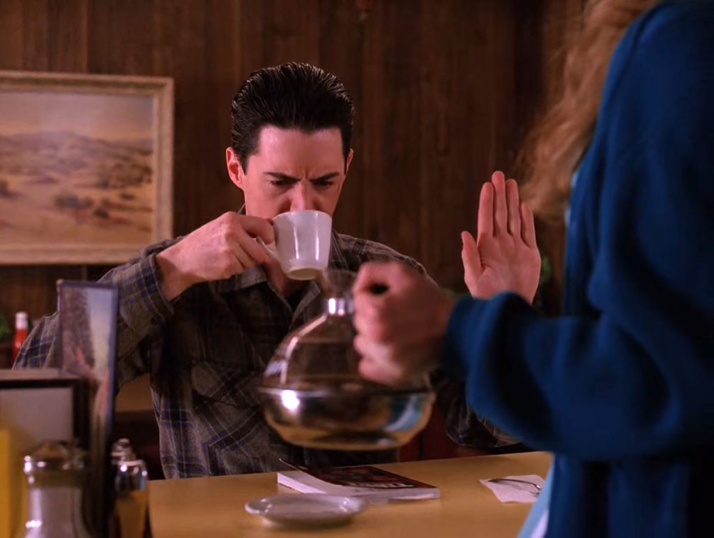 Dale Cooper drinking coffee as Annie Blackburn looks on