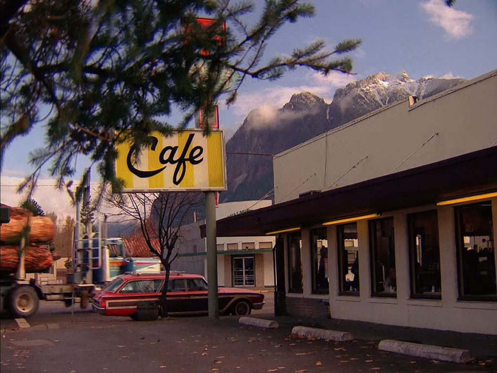 Exterior of the Double R Diner with a logging truck passing