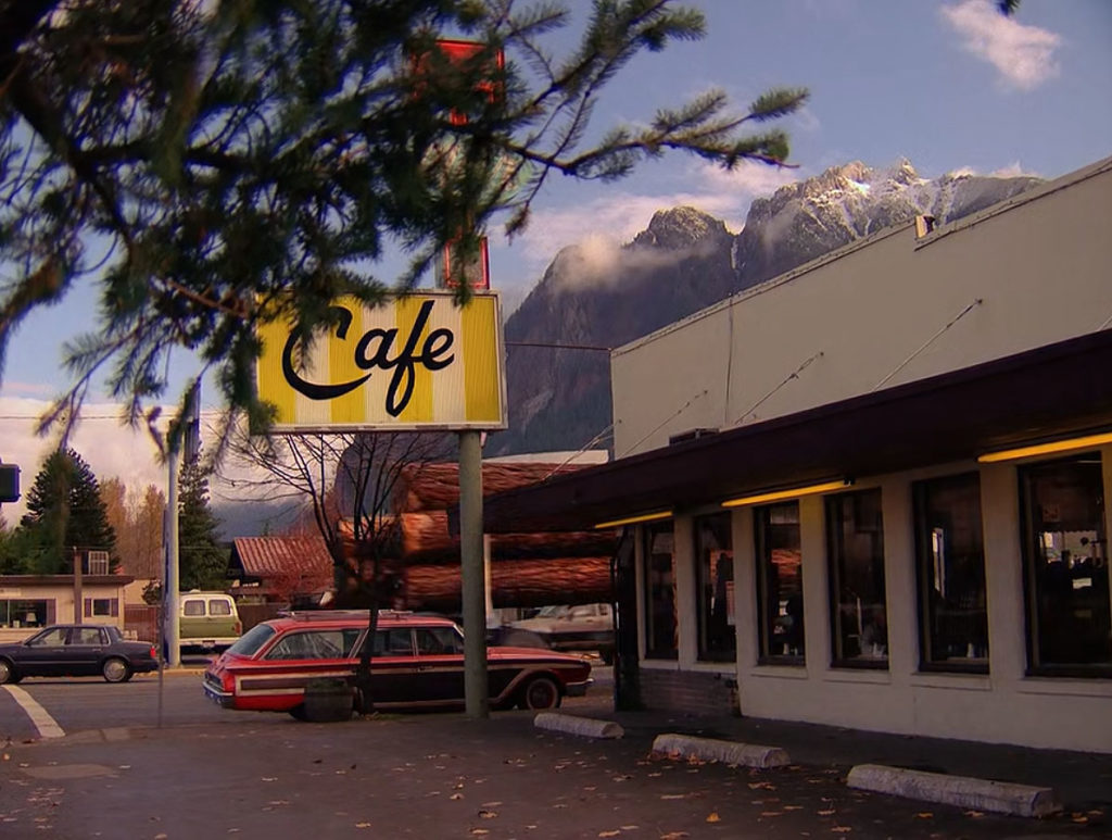Exterior of the Double R Diner with a logging truck passing
