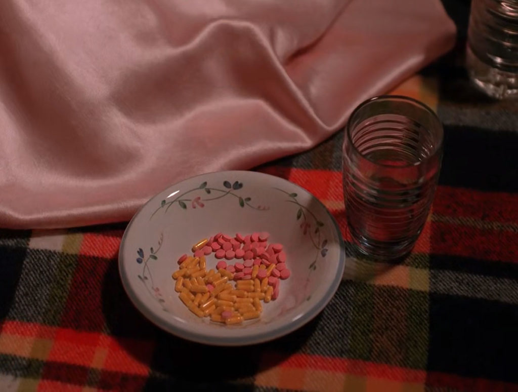 Nadine's dress next to a bowl of pills and a glass of water