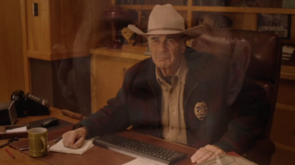 Sheriff Frank Truman sitting at his desk