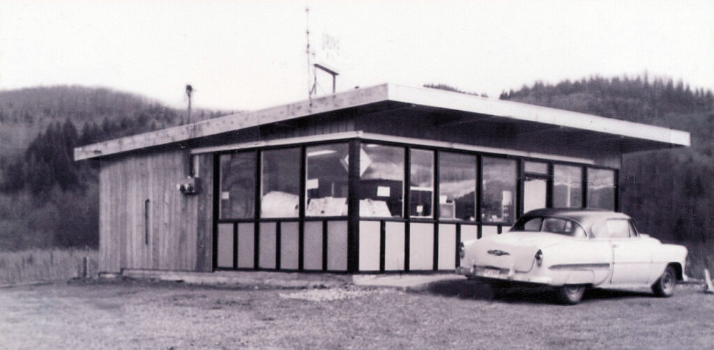 Black and white image of Bob's Drive-In with a white car parked out front.