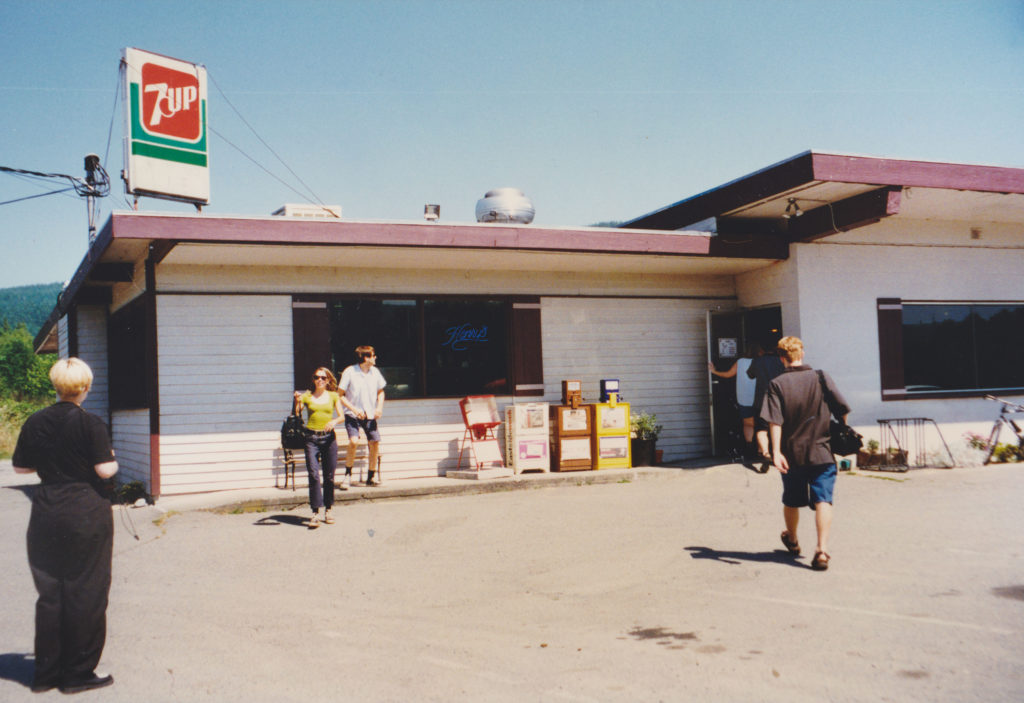 Restaurant building with people in the parking lot and a 7-UP sign on the roof
