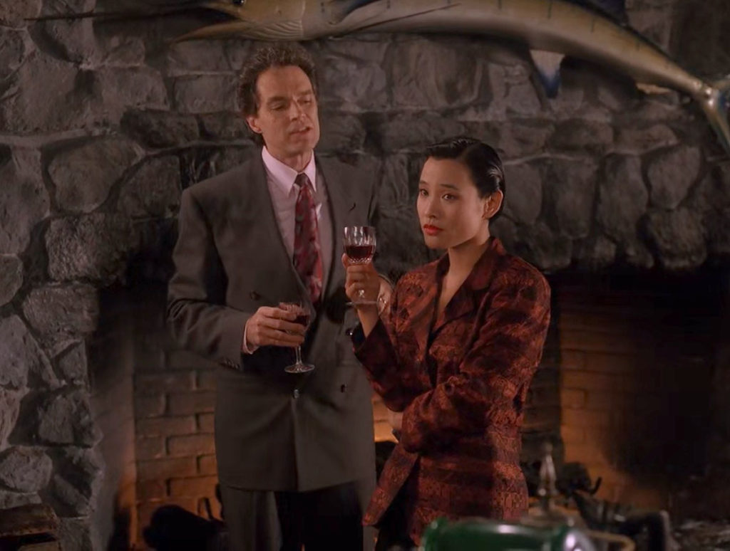 Ben Horne and Josie Packard by a fireplace with wine glasses