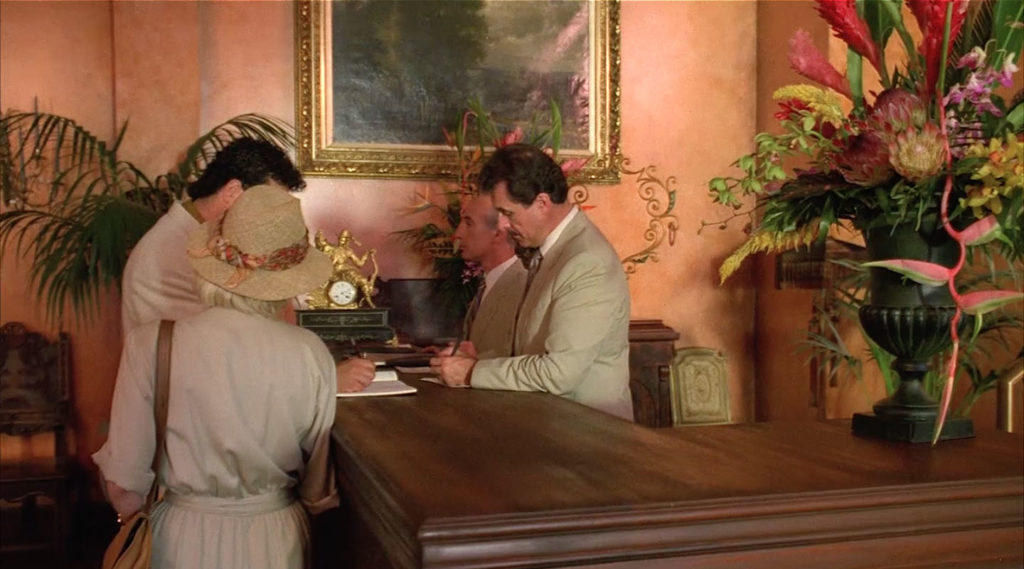 Two people checking into the the Palm Deluxe hotel at the front desk in Twin Peaks - Fire Walk With Me