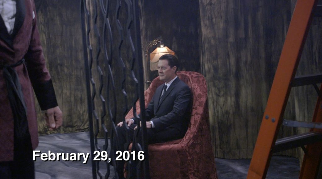 Kyle MacLachlan sitting in a chair