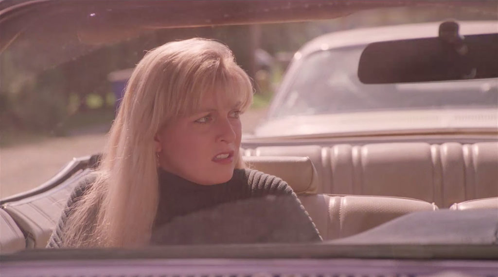 Laura Palmer looking concerned sitting in the passenger seat