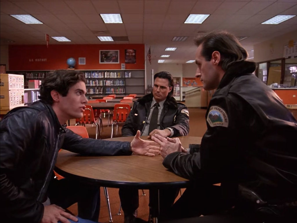 Bobby Briggs sitting at a table in the Library talking with Deputy Hawk and Deputy Brennen