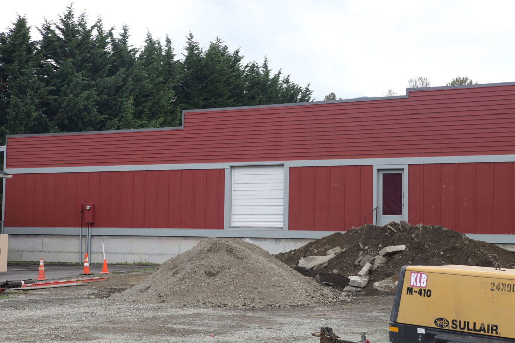 Red Building with piles of dirt in parking lot