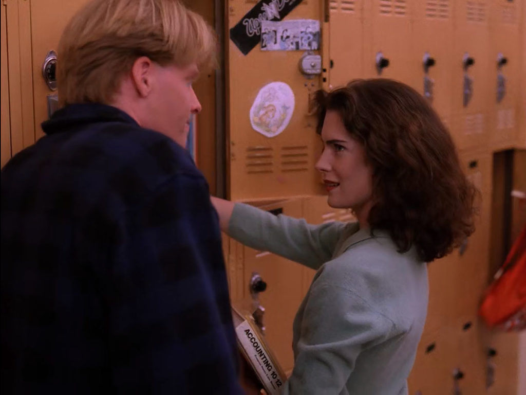 Donna Hayward speaking to Mike Nelson by yellow lockers