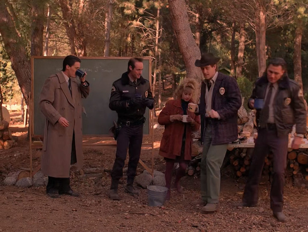 Special Agent Dale Cooper and Twin Peaks Sheriff's Department drinking coffee in the woods by a chalkboard