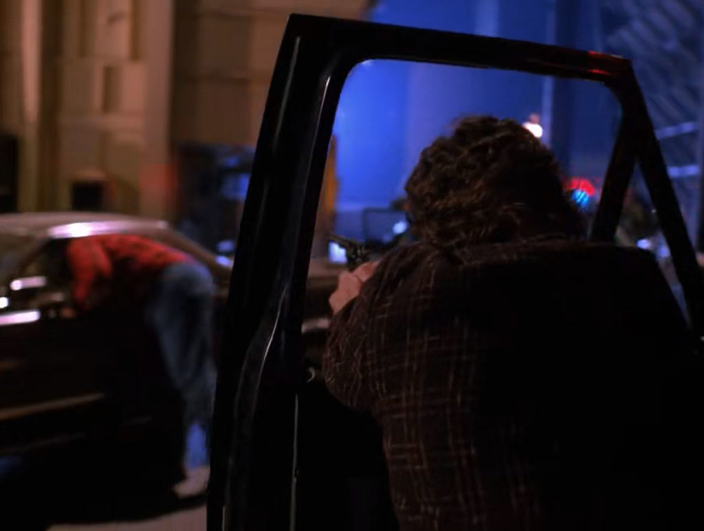 Sheriff Truman aiming his gun through car window