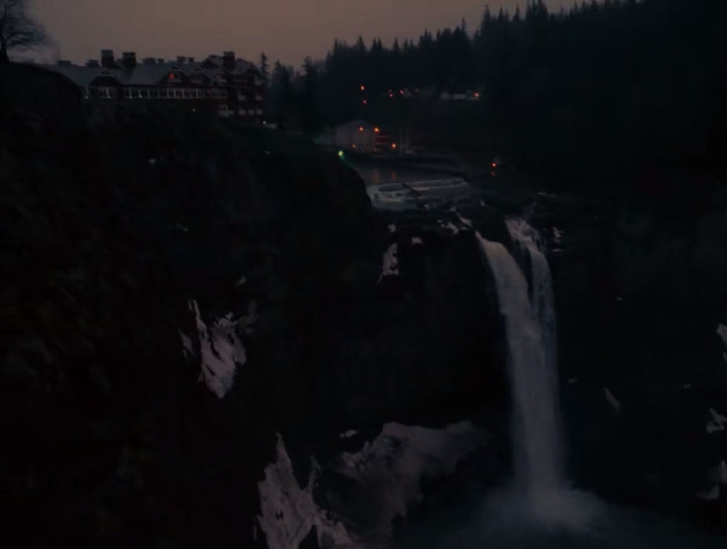 White Tail Falls surrounded by snow with The Great Northern Hotel perched above