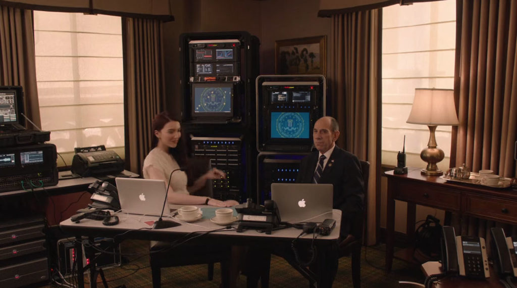 Agents Preston and Rosenfield at a desk surrounded by computer equipment