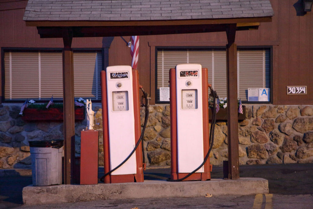 Red and white gas pumps under a covered area