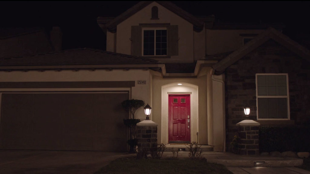 Exterior of home at night with red door