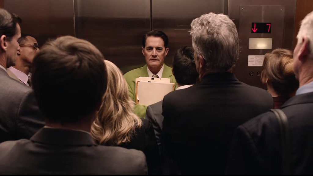 Dougie Jones standing in a crowded elevator