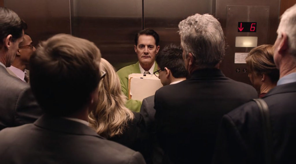 Dougie Jones standing in a crowded elevator