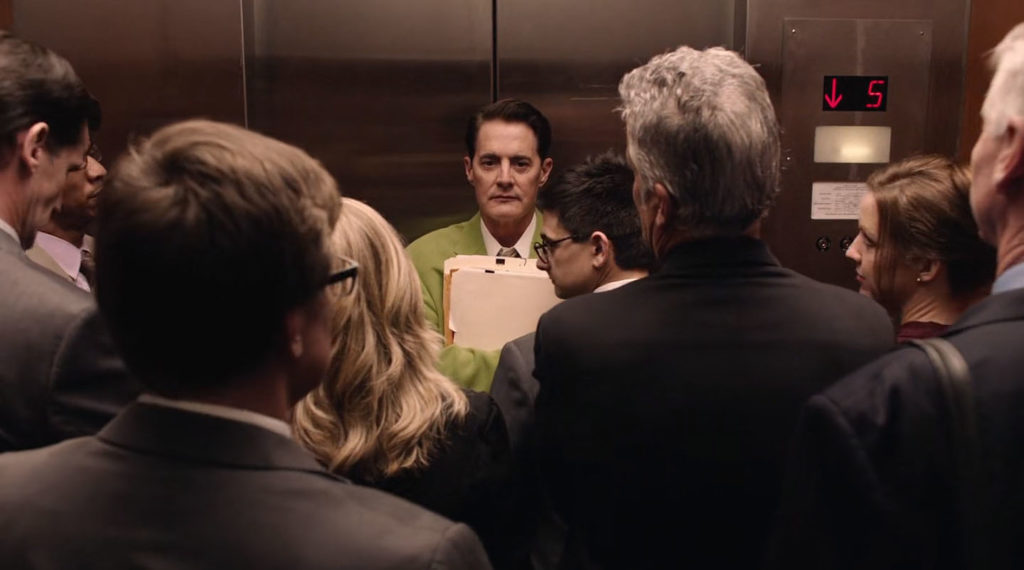 Dougie Jones standing in a crowded elevator