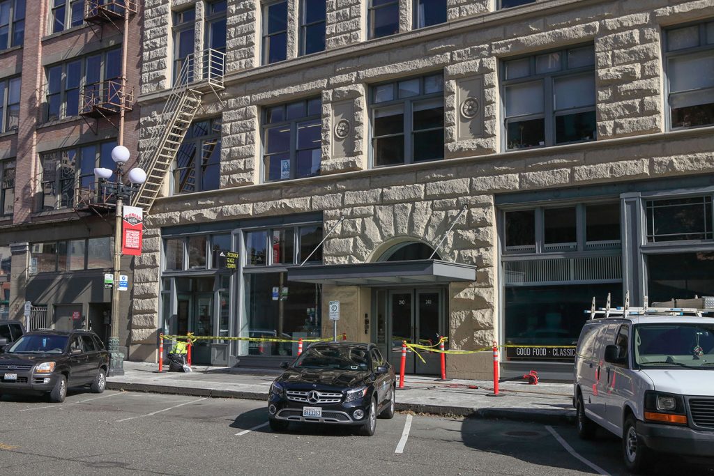 Front of the Baker Building in downtown Seattle with cars parked along the street