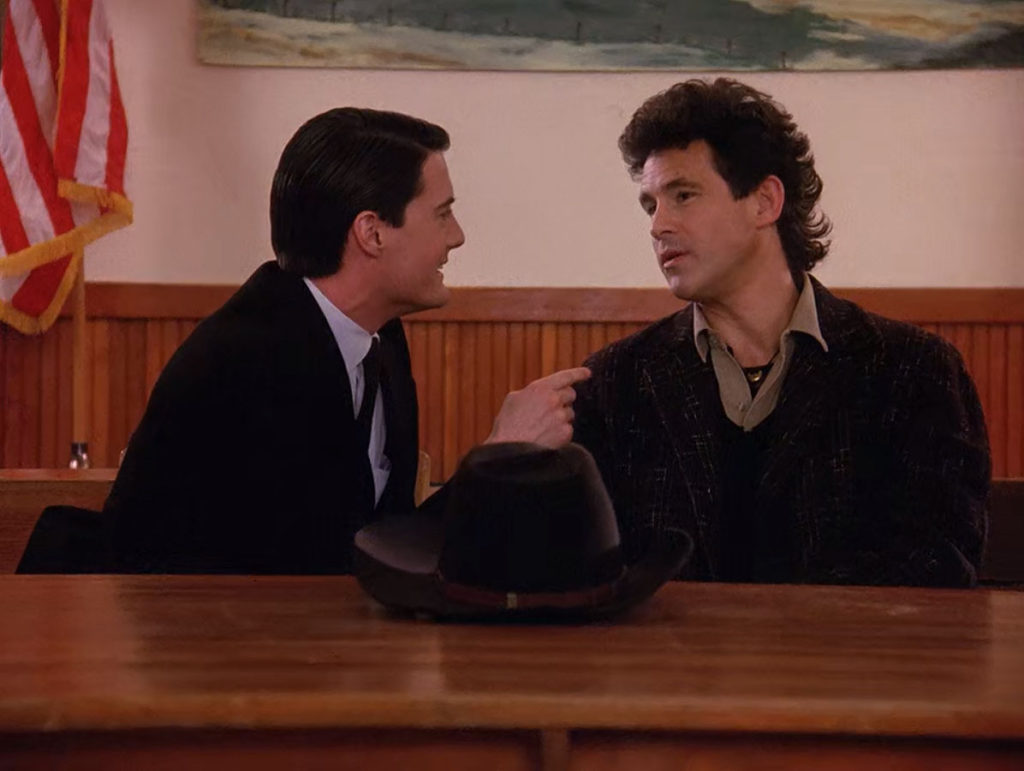 Agent Cooper and Sheriff Harry Truman discuss at a table