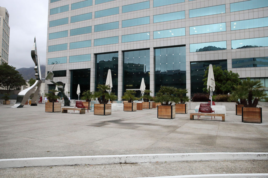 Office building with wooden planters and seating in courtyard