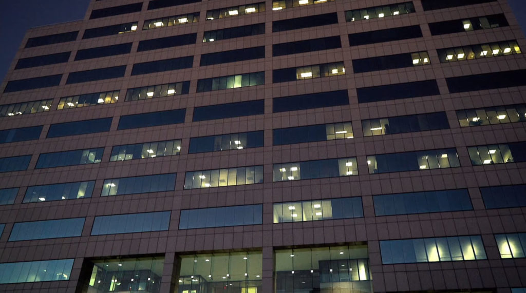 Nighttime exterior of Insurance Building with lights on in office windows