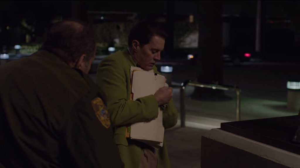 Security guard speaking with Dougie Jones who is holding files