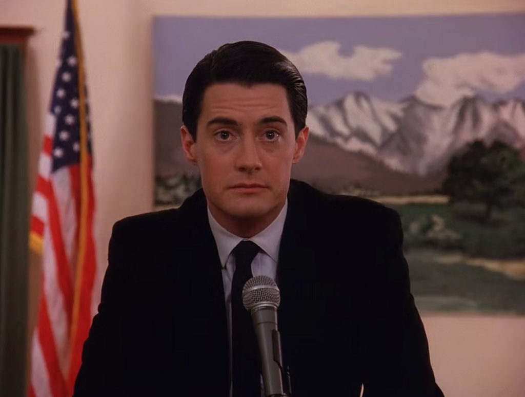 Agent Cooper dressed in black suit, tie and blue shirt