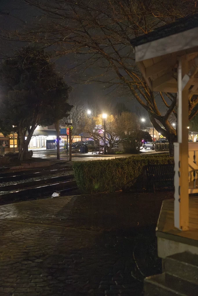 Sidewalk by Gazebo and railroad tracks at night