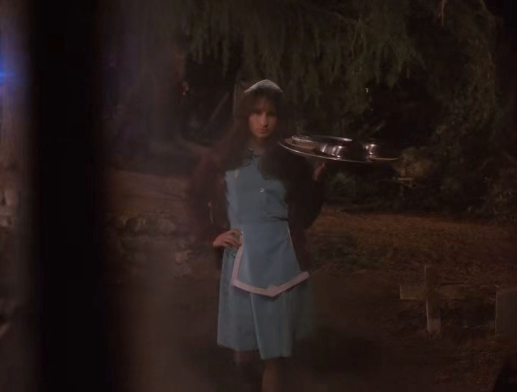 Agent Denise Bryson dressed as in a Double R Diner waitress uniform carrying a tray