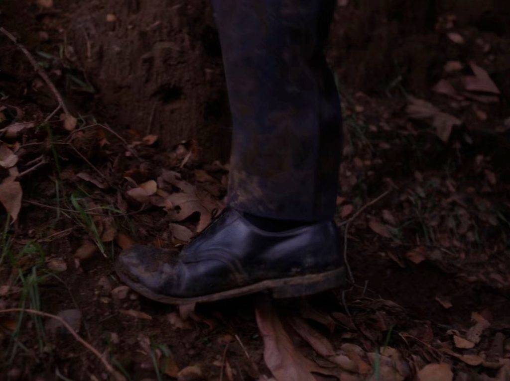 Major Briggs' leg and shoe in dirt