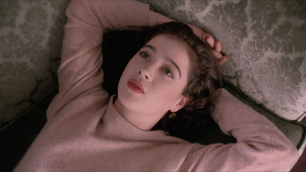 Donna Hayward laying on couch with arms above head