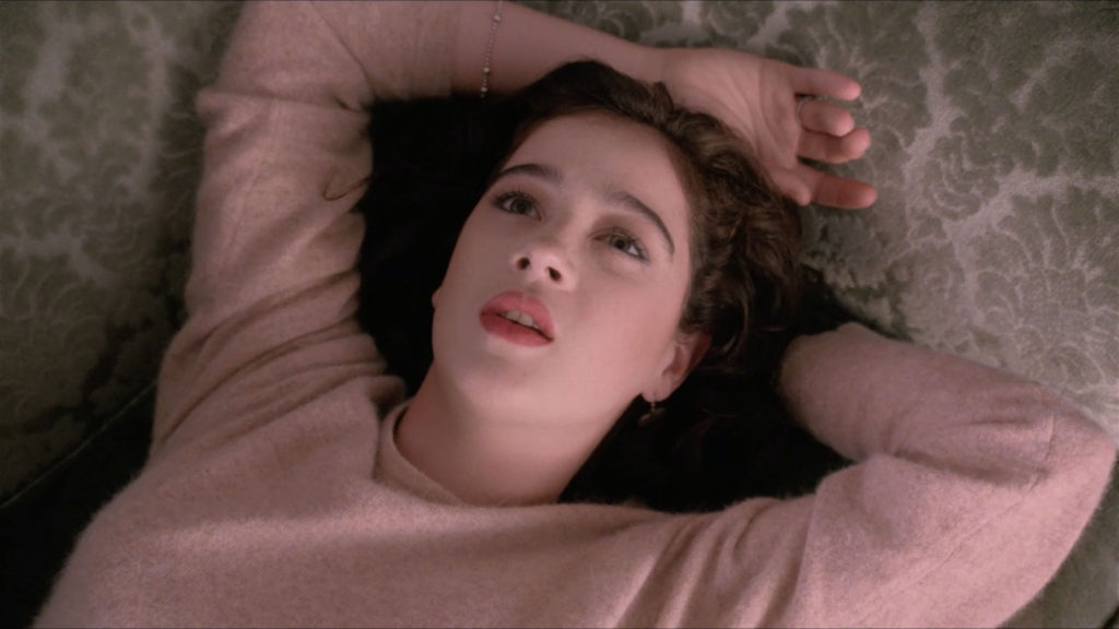 Donna Hayward laying on couch with arms above head