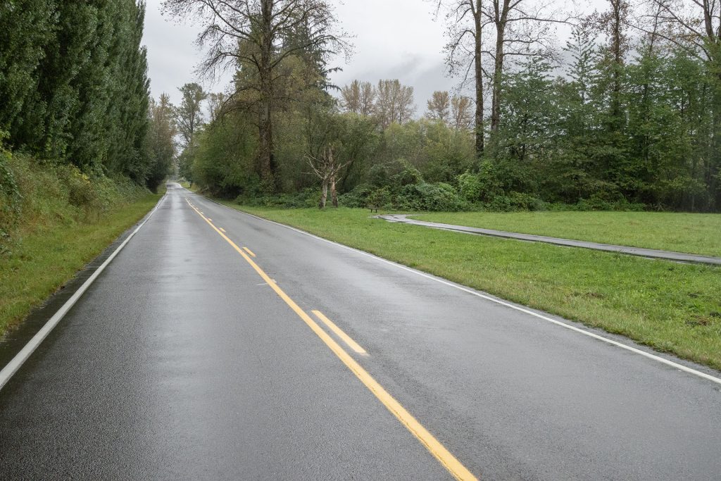 Road running by field with a walking track