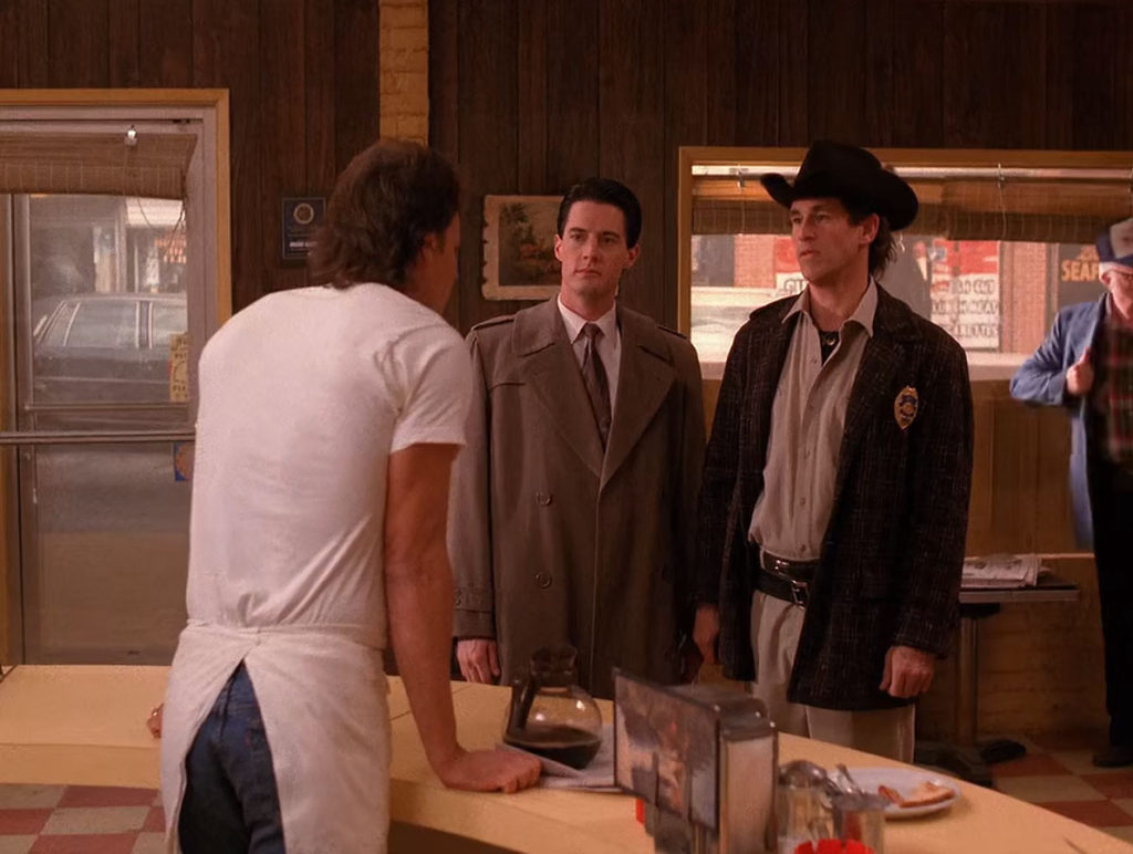 Hank Jennings speaking with Agent Cooper and Sheriff Truman