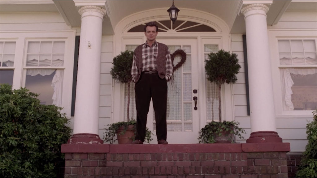 Leland Palmer standing on the front porch of his home