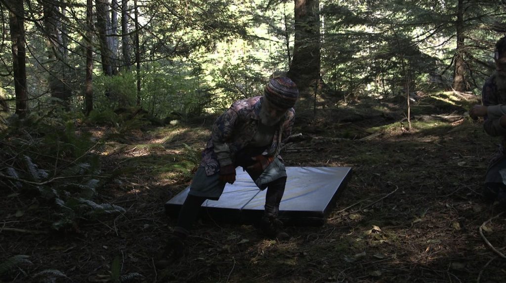 David Patrick Kelly rehearsing a scene with a pad in the woods