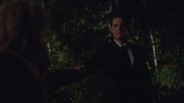 Cooper holding out his hand in the woods