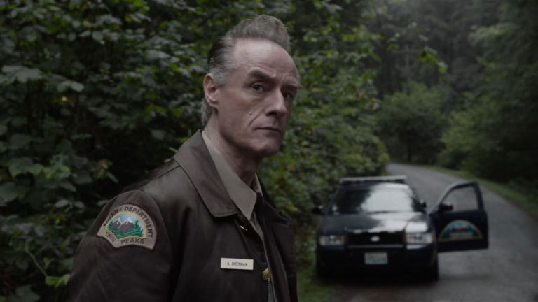 Andy standing on a road in front of his squad car