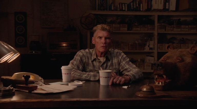 Big Ed sitting at his desk