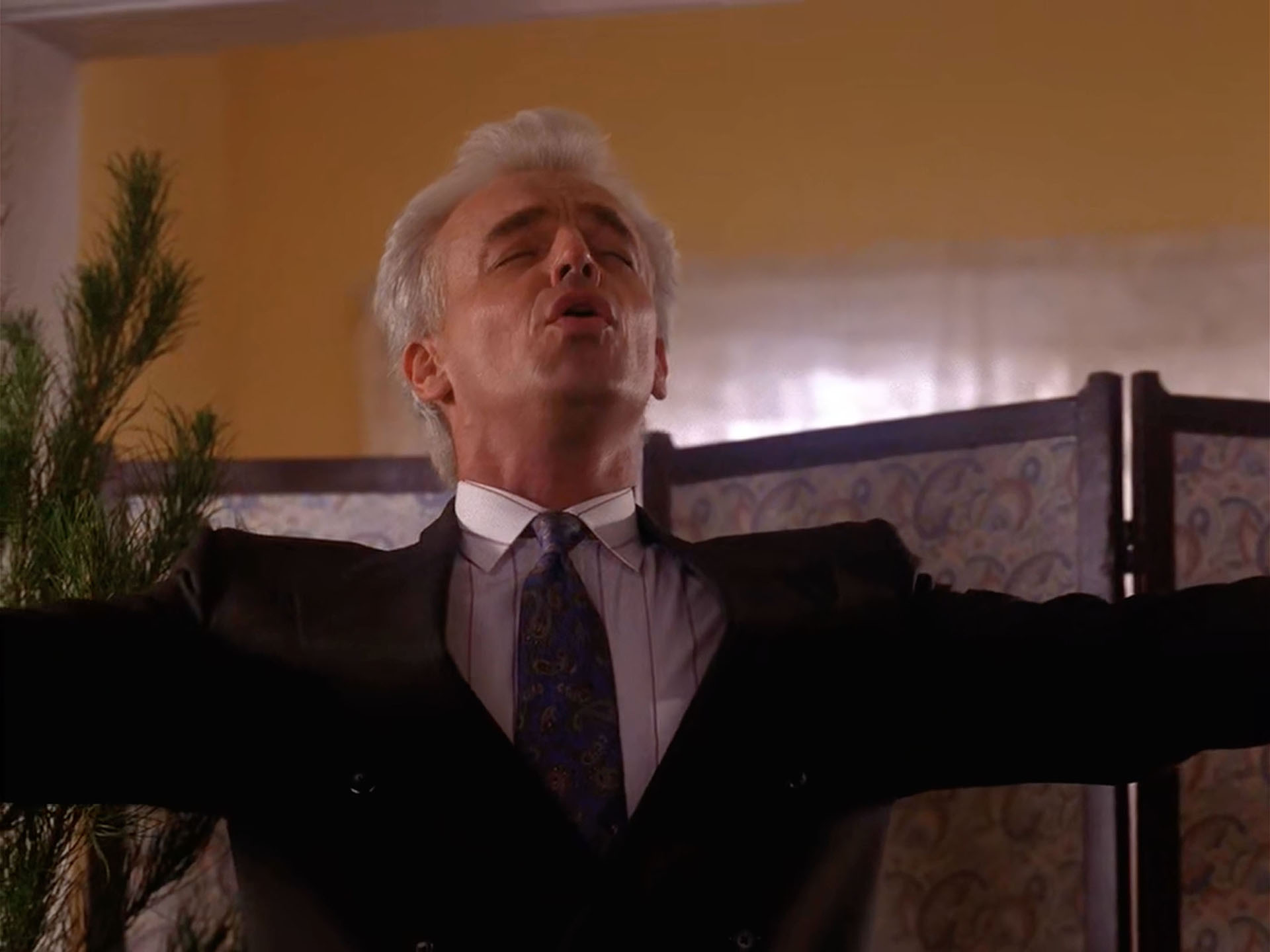 Leland Palmer with arms outstretched and singing