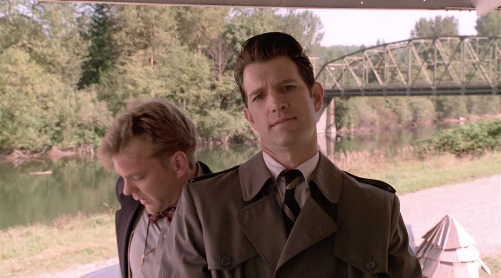 Agent Sam Stanley and Agent Chet Desmond with a river and bridge behind them