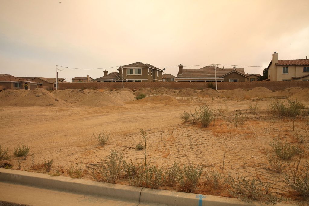 Dirt land with houses in the distance